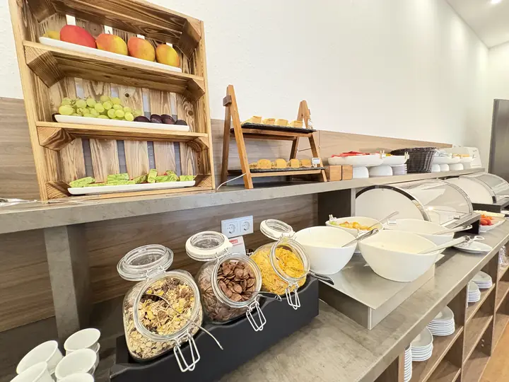 Breakfast buffet with fruit, cereal and rolls