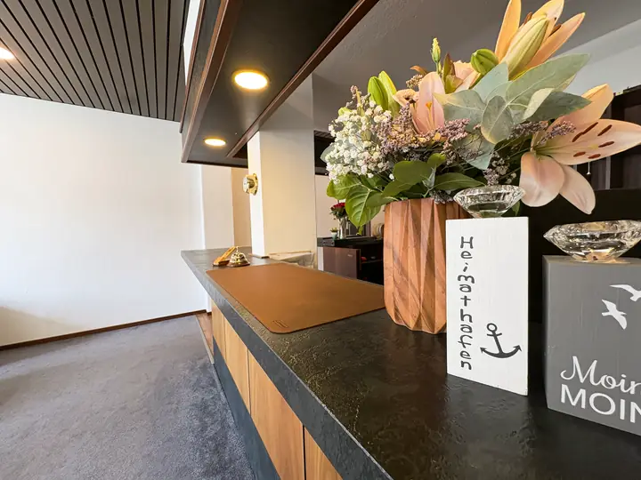 Reception desk with flowers and a “Moin” sign