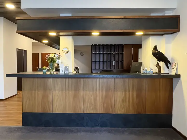 Wooden reception desk with the hotel's raven figure