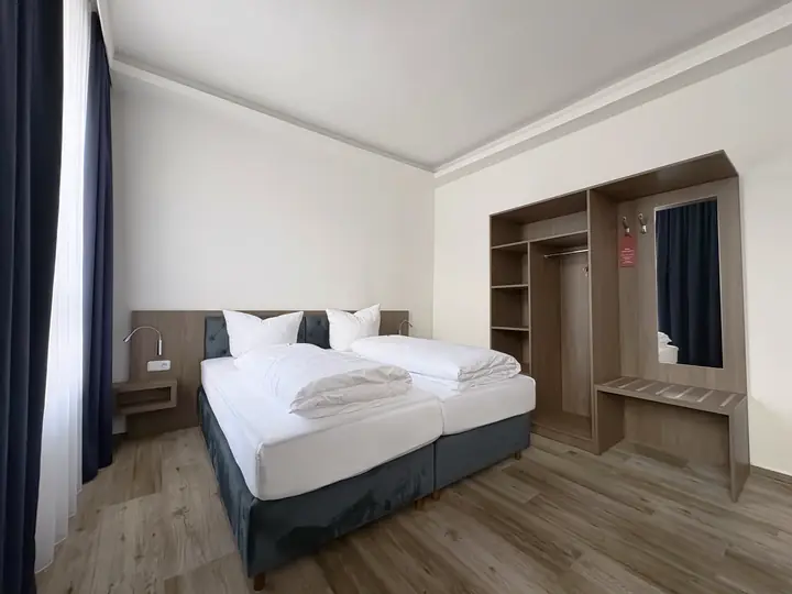 Doppelbett und offener Schrank im blauen Zimmer
