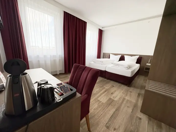 Schreibplatz mit Wasserkocher und Sessel im weinroten Zimmer