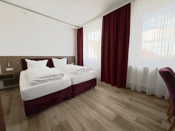 Bett am Fenster im weinroten Zimmer